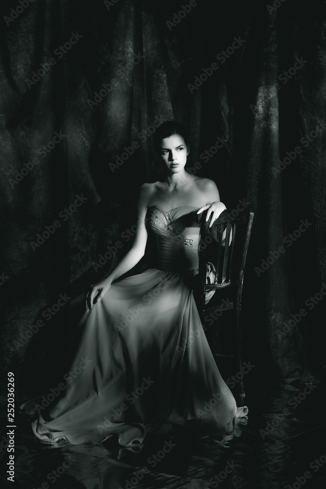 Beautiful woman in evening dress on dark background