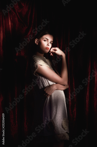Beautiful woman in white dress on dark burgundy background