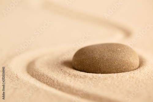 Healing treatment or spiritual therapy trough relaxation and meditation concentrating on a zen stone garden. Spa wellness background with sand texture.
