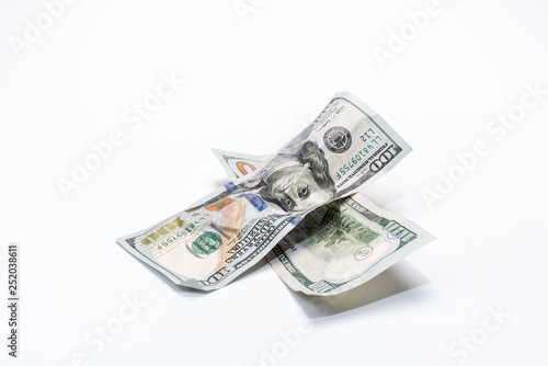 Crumpled dollar banknotes in cross shape form on white background..
