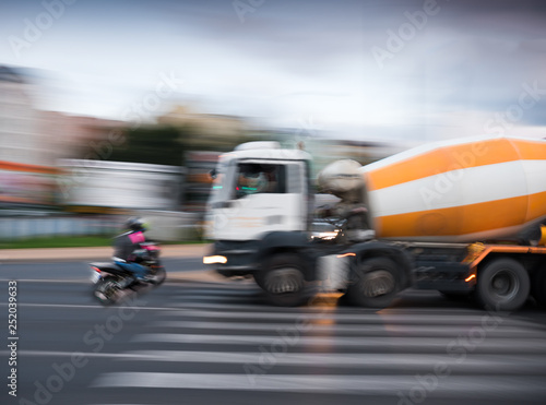 Dangerous city traffic situation with a motorcyclist and a truck