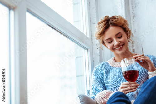 Foto Cheerful positive woman looking at the wine
