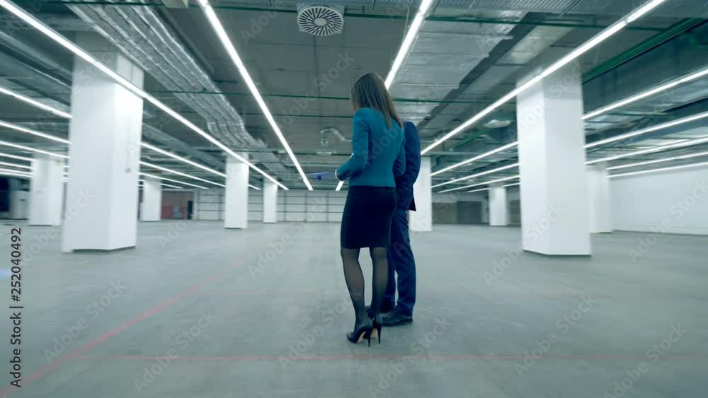 People talk while working with a business plan in a commercial retail space. People talk while working with a business plan in a commercial retail space.