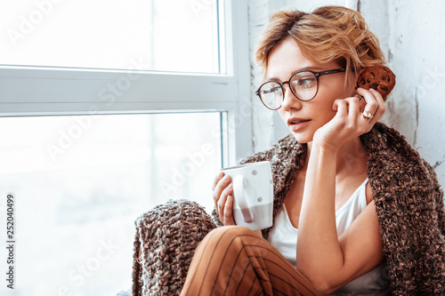 Sad thoughtful woman sitting with a cup of tea