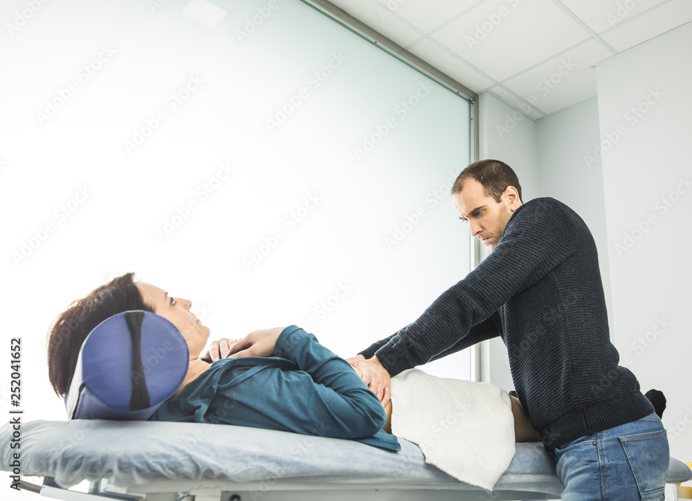 Physiotherapist massaging the belly of a young woman.Concept Physiotherapy Physiotherapist massaging the belly of a young woman.Concept Physiotherapy
