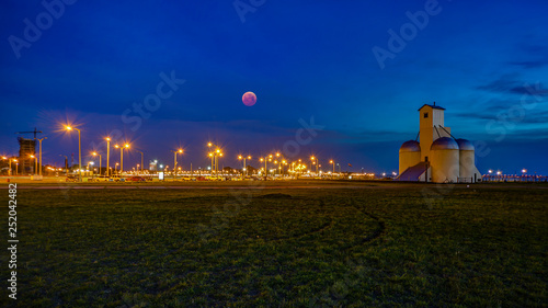 Dusk / blue hour with blood moon at Playa San Jose of Encarnacion in Paraguay.. photo