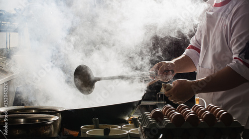 Chef stir fry in wok © U2M Brand