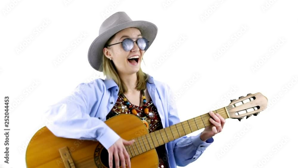 Funny young woman in hat playing acoustic guitar on white background Funny young woman in hat playing acoustic guitar on white background