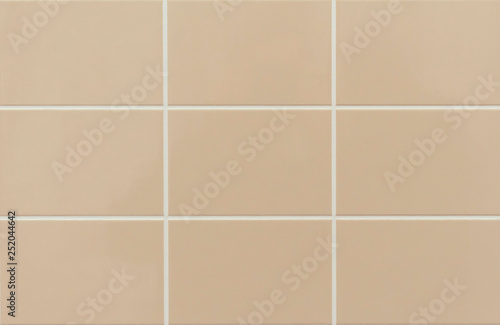 Beige ceramic tile on the wall in the bathroom. Background from beige tiles.