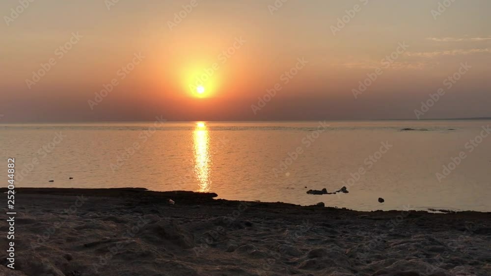Sunrise over the calm sea. Summer sun reflected from the water. Sea of Azov. Sunrise over the calm sea. Summer sun reflected from the water. Sea of Azov.