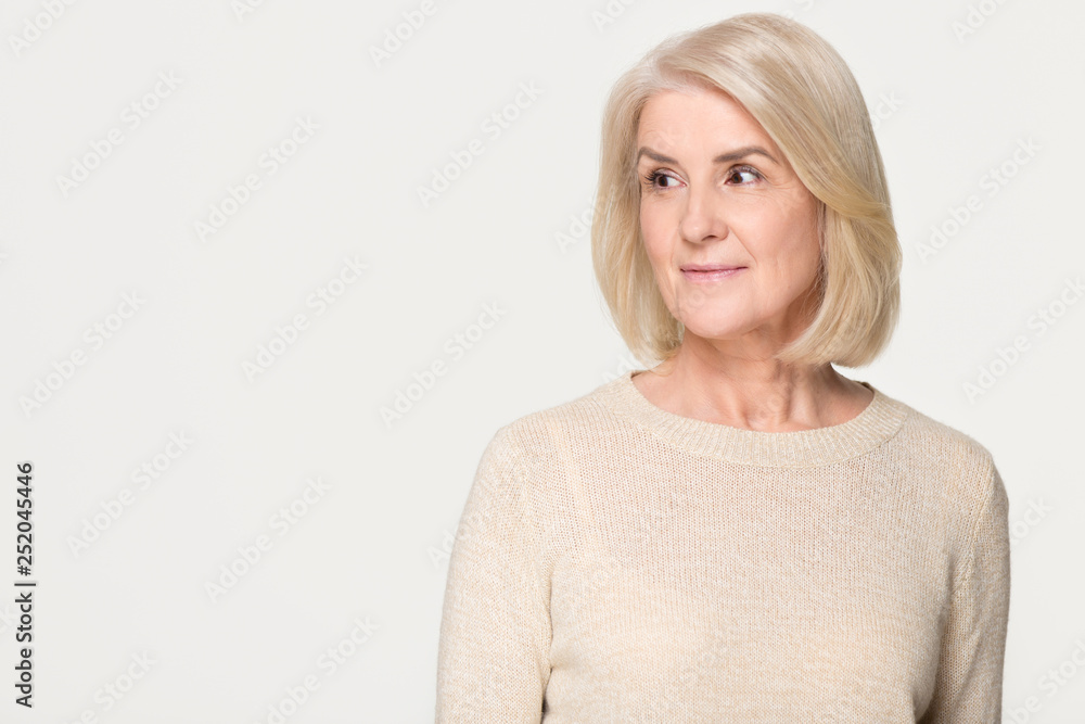 Dreamy mature woman looking at copy space isolated on background Dreamy mature woman looking at copy space isolated on background
