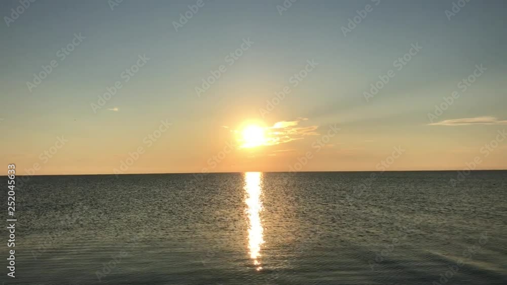 Sunrise over the calm sea. Summer sun reflected from the water. Sea of Azov. Sunrise over the calm sea. Summer sun reflected from the water. Sea of Azov.