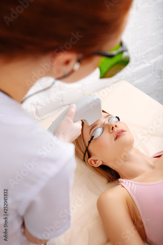 Depilatory master and client wearing glasses during photo depilation