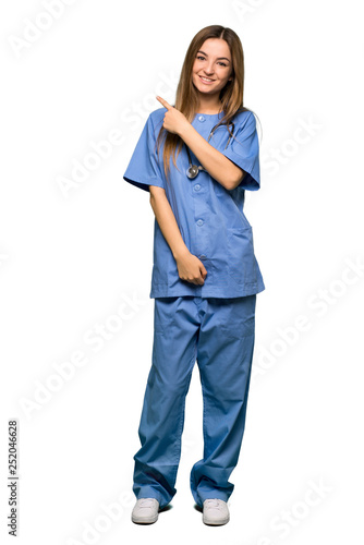 Full body Young nurse pointing to the side to present a product on isolated background