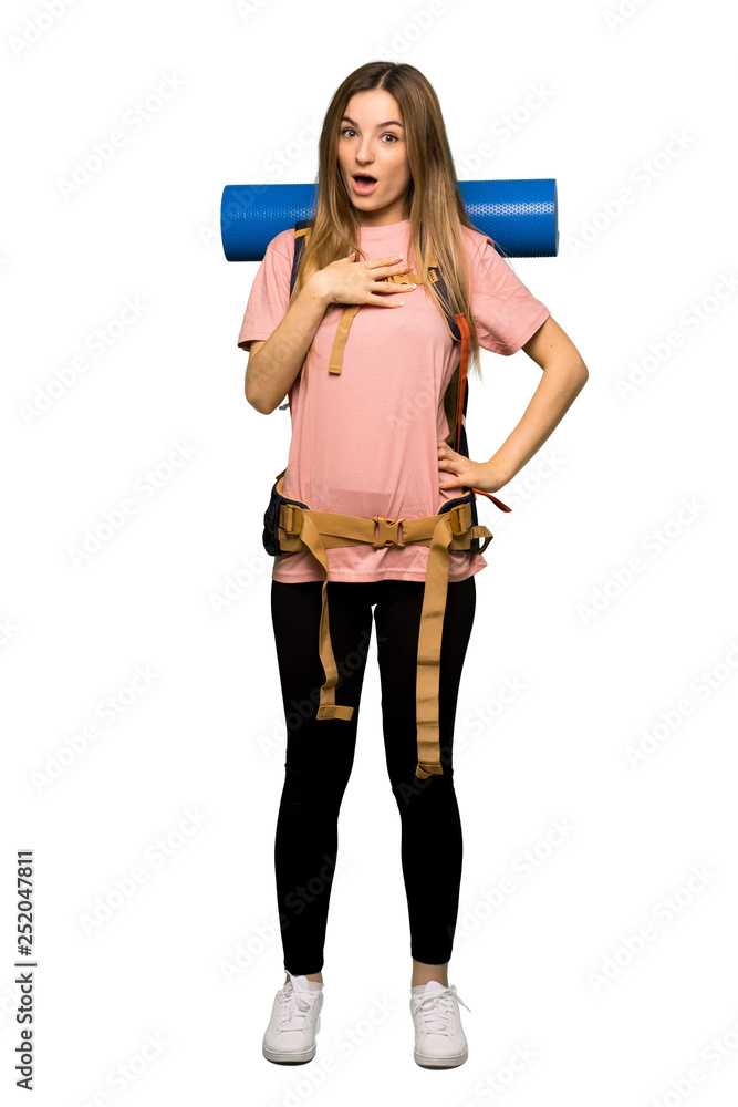 Full body Young backpacker woman surprised and shocked while looking right on isolated background Full body Young backpacker woman surprised and shocked while looking right on isolated background