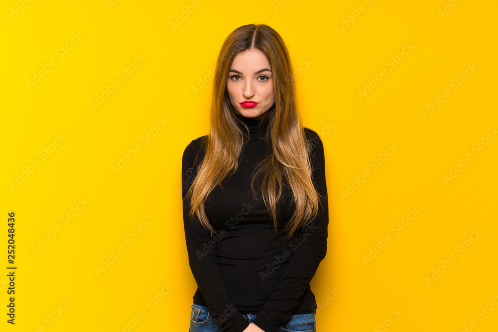 Young pretty woman over yellow background with sad and depressed expression Young pretty woman over yellow background with sad and depressed expression