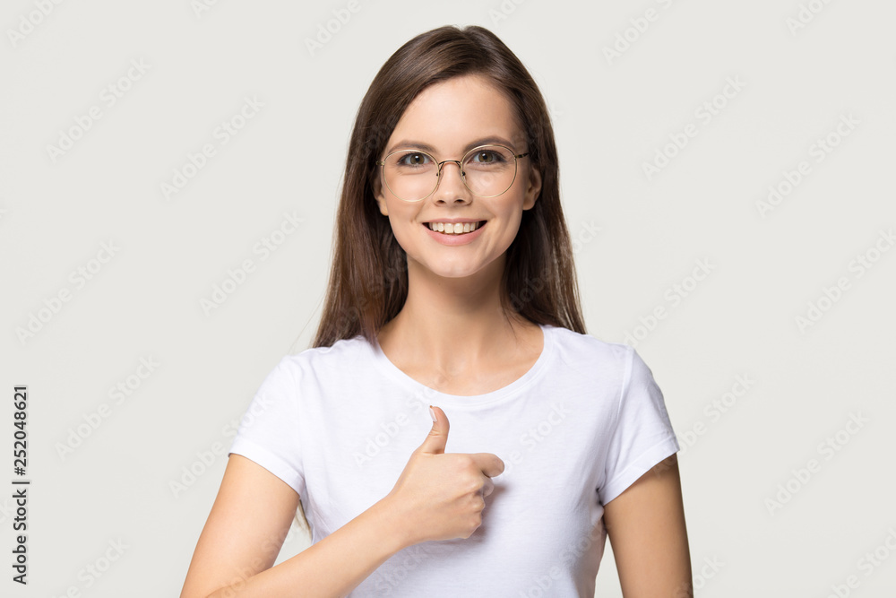 Happy girl showing thumbs up like gesture isolated on background Happy girl showing thumbs up like gesture isolated on background