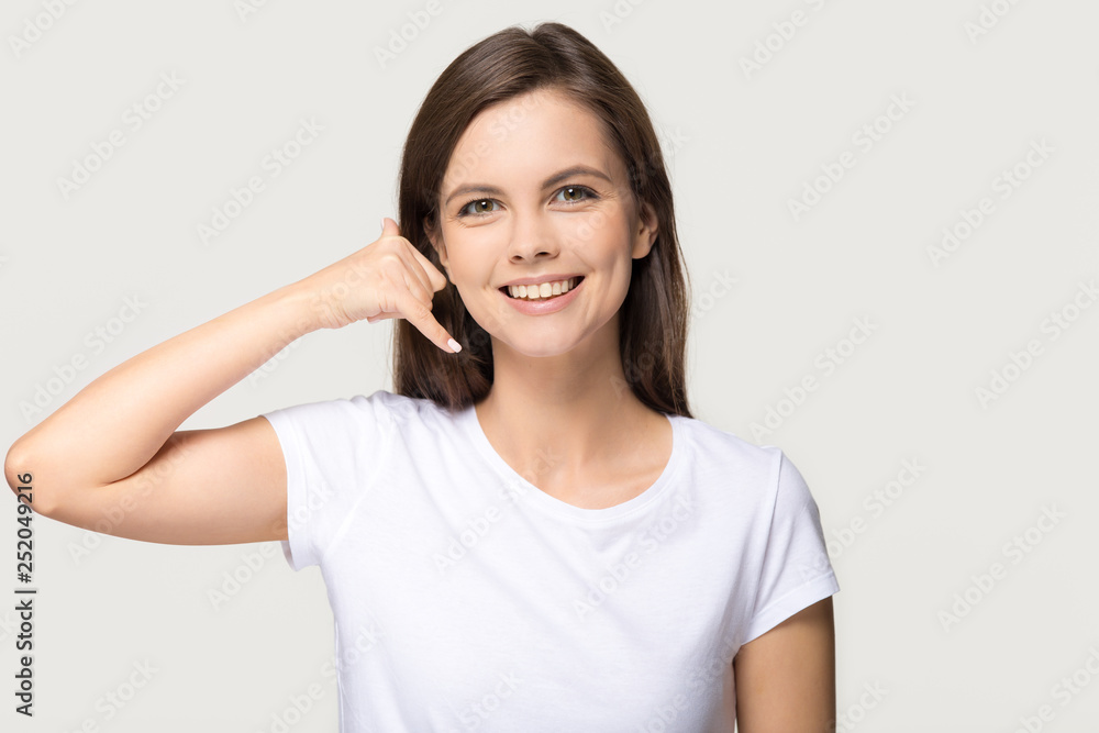 Happy girl showing call me phone gesture isolated on background Happy girl showing call me phone gesture isolated on background