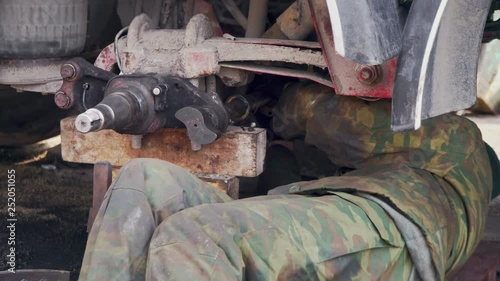 A mechanic at the station repairs the chassis of truck