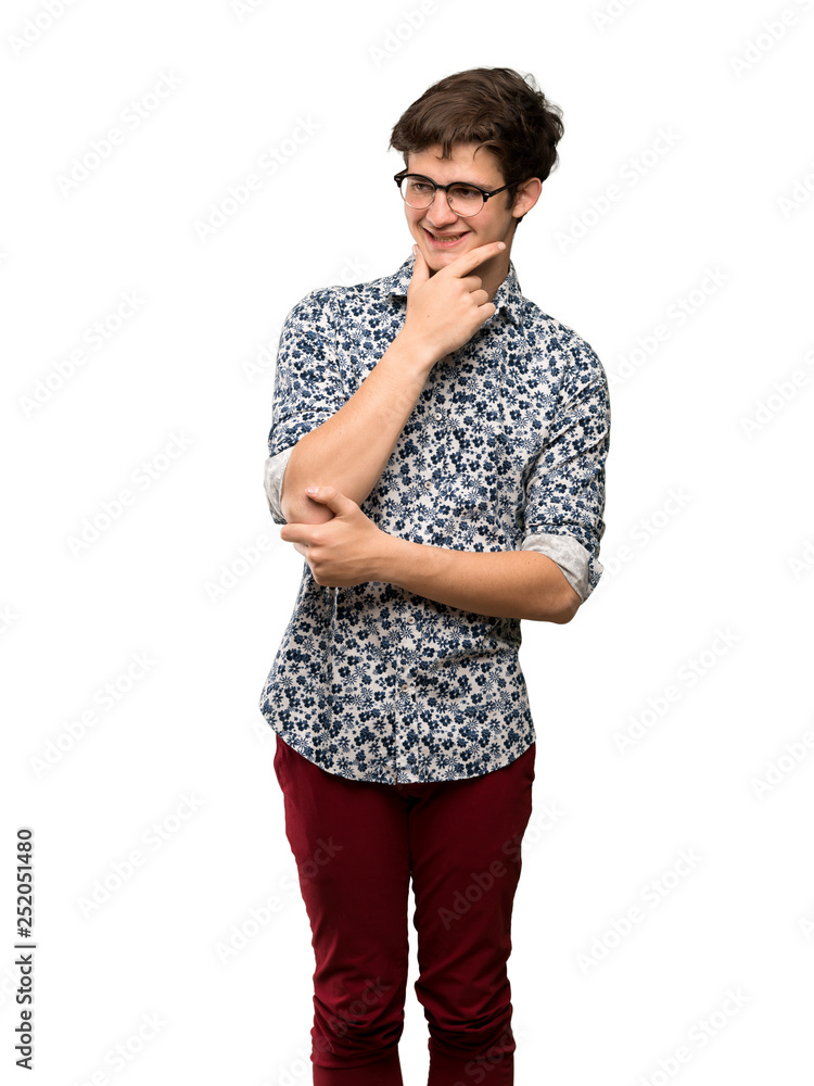 Teenager man with flower shirt and glasses looking to the side over isolated white background Teenager man with flower shirt and glasses looking to the side over isolated white background