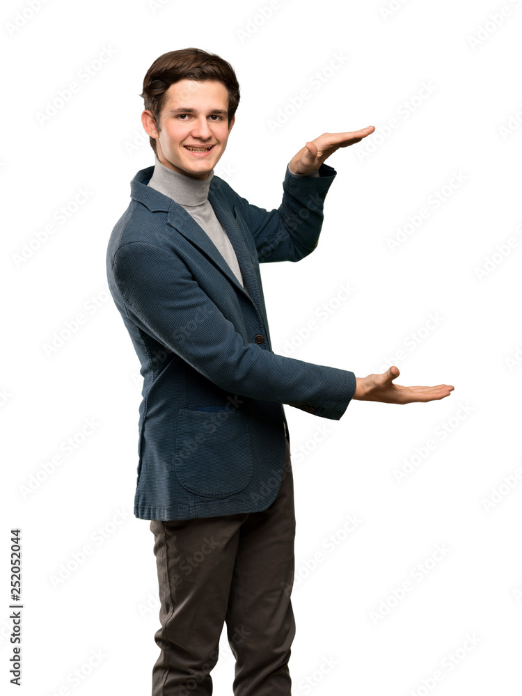 Teenager man with turtleneck holding copyspace to insert an ad over isolated white background Teenager man with turtleneck holding copyspace to insert an ad over isolated white background