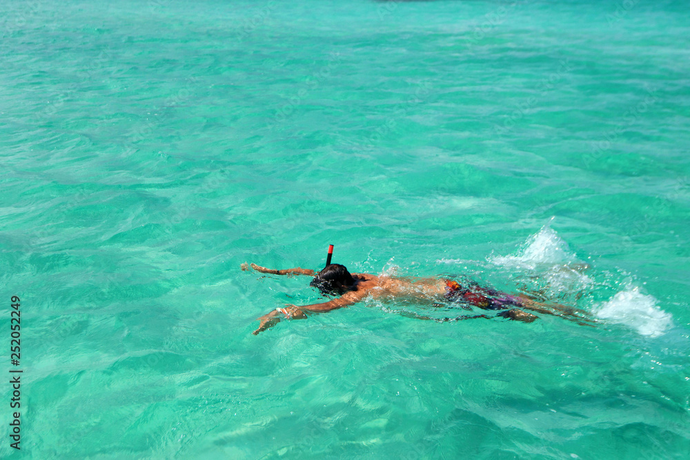 View of young boy snorkelling in clean green water