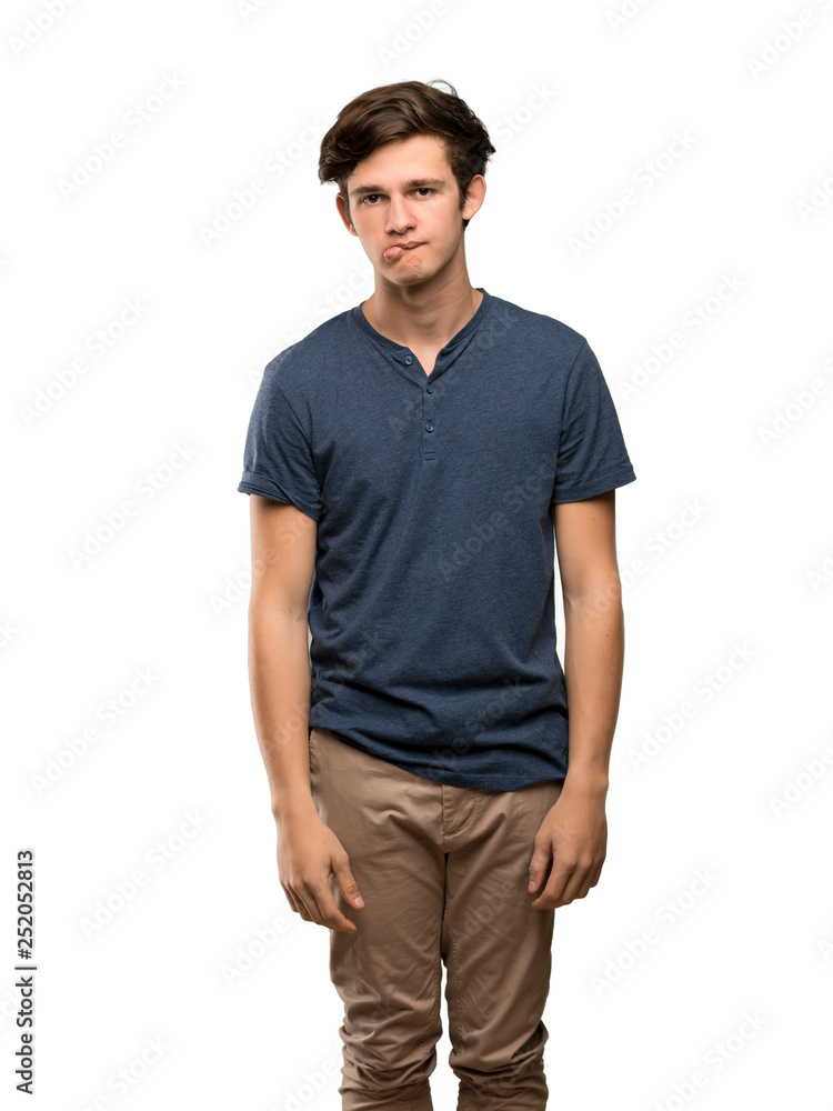Teenager man with confuse face expression while bites lip over isolated white background Teenager man with confuse face expression while bites lip over isolated white background