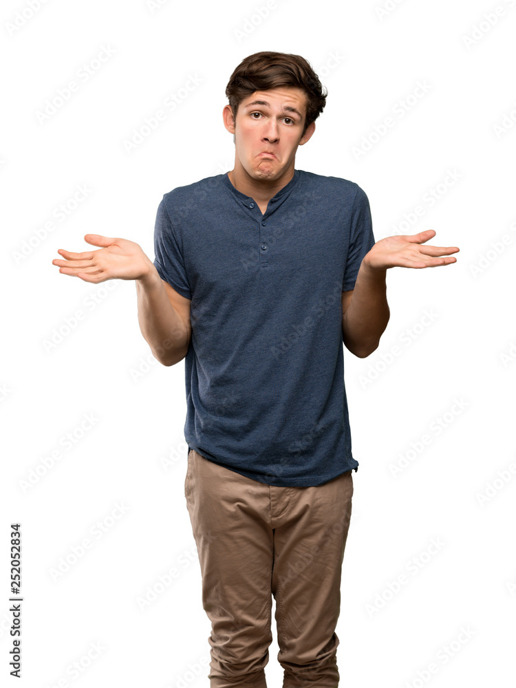 Fototapeta premium Teenager man having doubts while raising hands over isolated white background