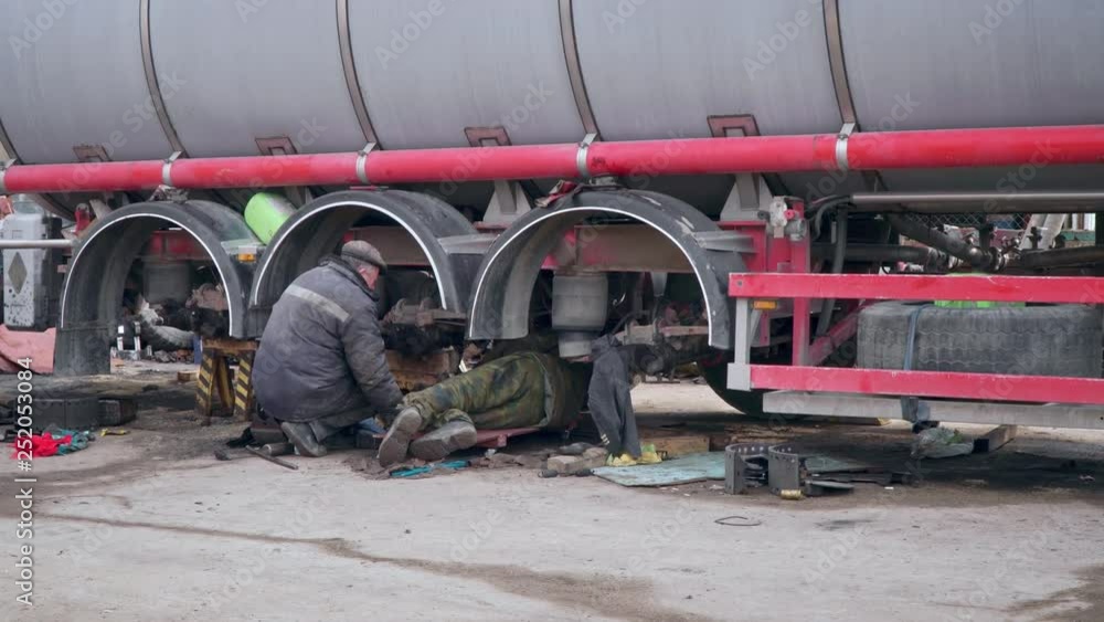 Mechanic repairing wheels of a truck on the station Mechanic repairing wheels of a truck on the station