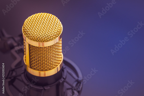 Close-up condenser gold microphone with luxury. Composition on the left side with free space on the right. Artistic style.