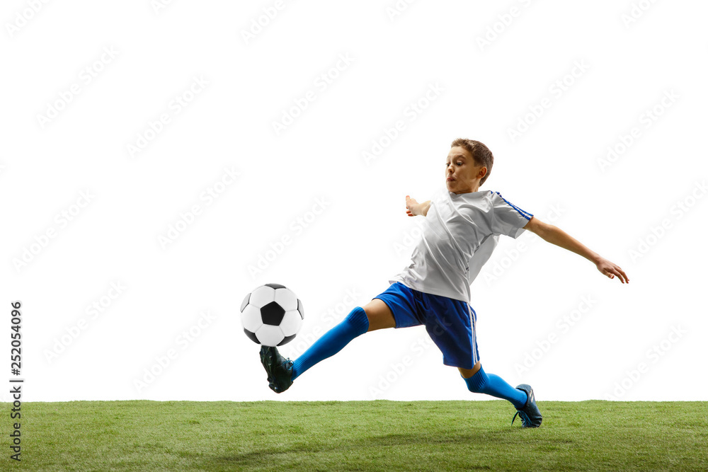 Young boy with soccer ball running and jumping isolated on white studio background. Junior football soccer player in motion