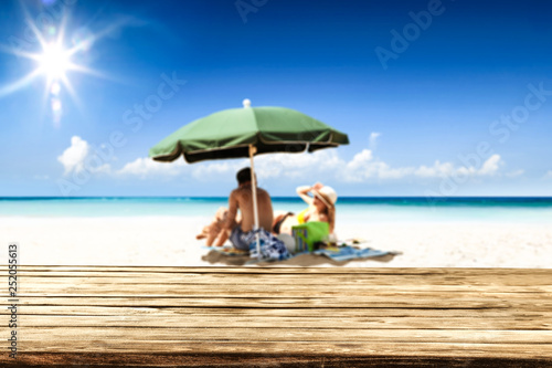 Desk of free space for your product. Beach landscape with people on towel. Ocean water and sun light © magdal3na