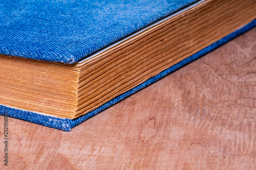 a book with a denim cover is lying on a wooden backing