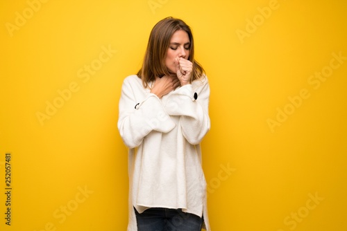 Blonde woman over yellow wall is suffering with cough and feeling bad © luismolinero
