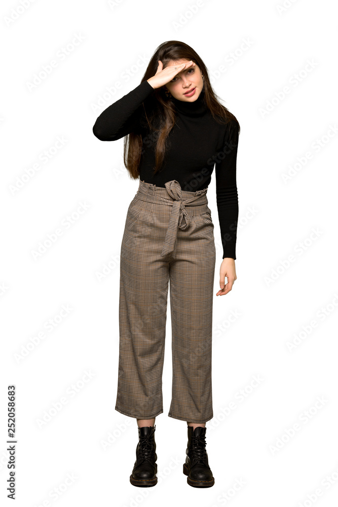 Full-length shot of Pretty girl looking far away with hand to look something on isolated white background Full-length shot of Pretty girl looking far away with hand to look something on isolated white background