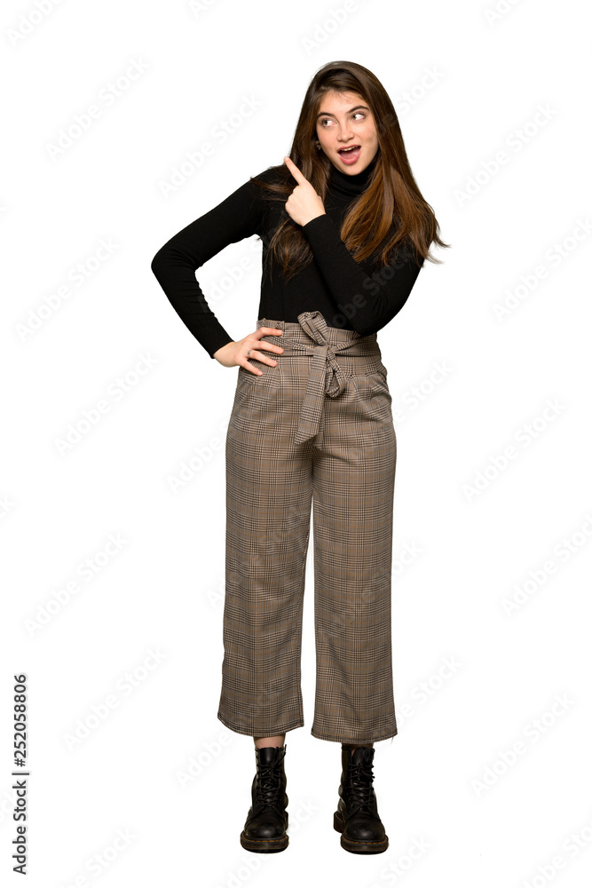 Full-length shot of Pretty girl surprised and pointing side on isolated white background Full-length shot of Pretty girl surprised and pointing side on isolated white background