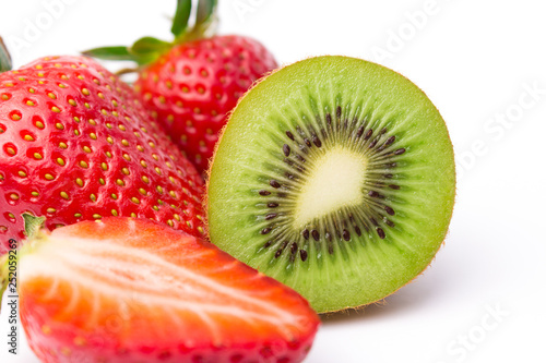 Halved kiwi fruit with strawberries on white