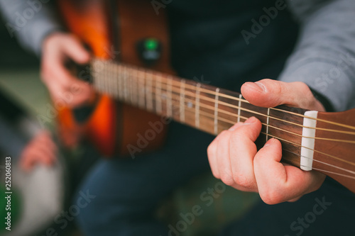 Playing on the shitara. Guitar. Guy with a guitar in his hand