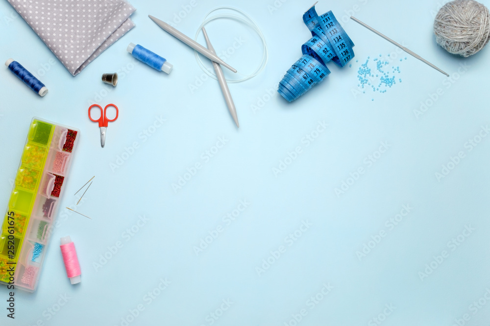 Set of sewing accessories on a blue background, top view Set of sewing accessories on a blue background, top view