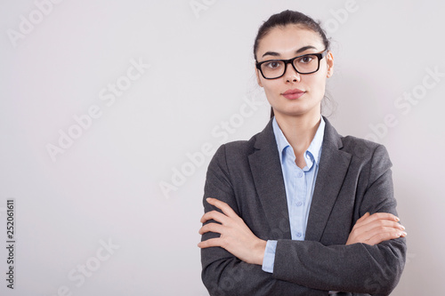 Young businesswoman on gray background