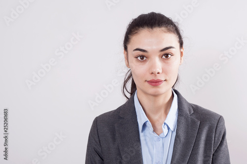 Young businesswoman on gray background