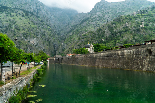 Green river in montenegro with ancient wall and mountains on background