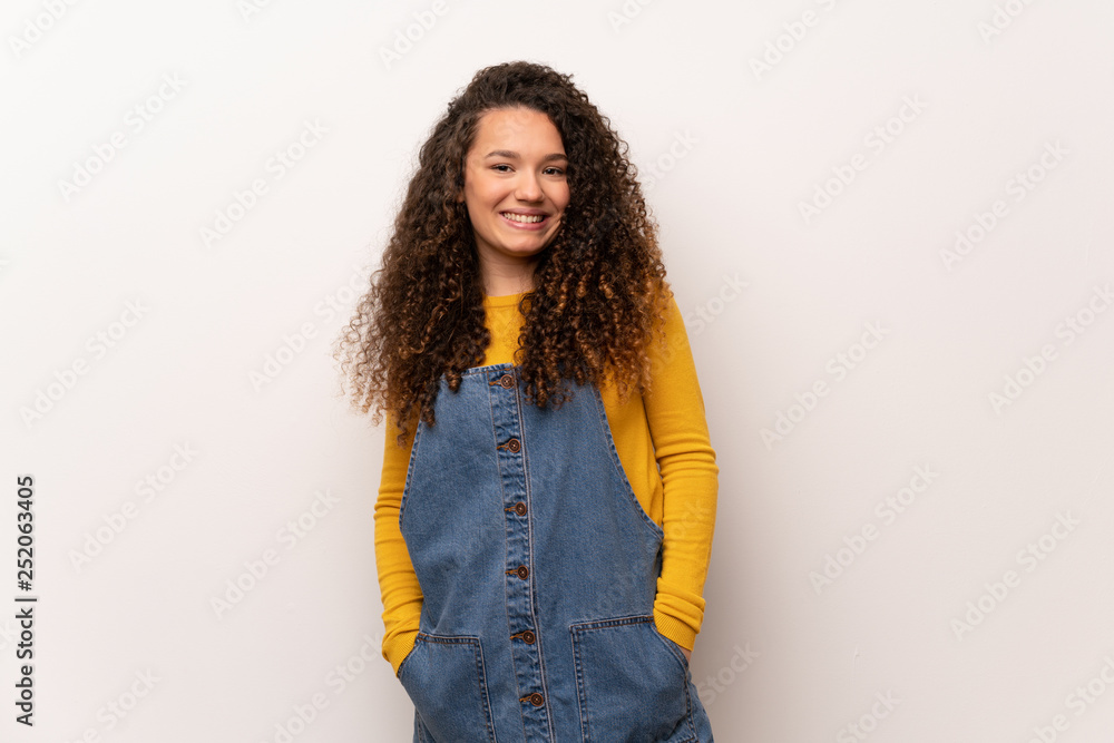 Teenager girl with red sweater over white wall laughing looking to the front Teenager girl with red sweater over white wall laughing looking to the front
