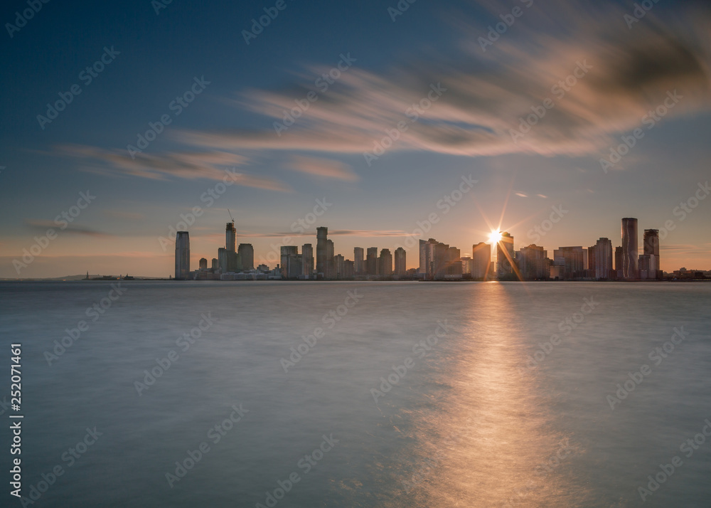 Jersey city with direct sun from hudson river with long exposure Jersey city with direct sun from hudson river with long exposure