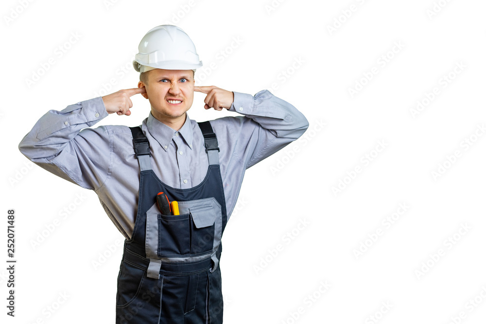 The builder in overalls and a protective helmet covers his ears with his hands. It is unbearable to hear the opinion of the customer about the work done. Isolated. The builder in overalls and a protective helmet covers his ears with his hands. It is unbearable to hear the opinion of the customer about the work done. Isolated.