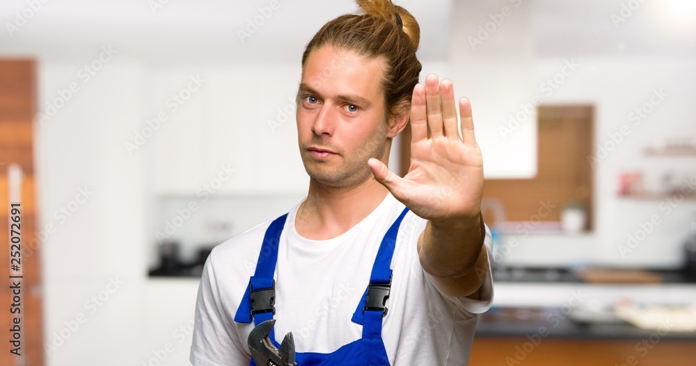 Workman making stop gesture denying a situation that thinks wrong in a house Workman making stop gesture denying a situation that thinks wrong in a house