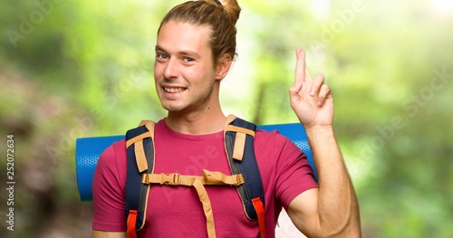 Hiker man with mountain backpacker with fingers crossing and wishing the best in the mountain