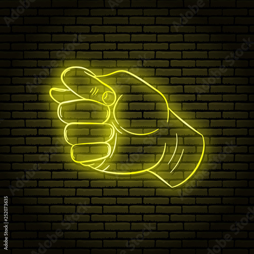 Neon sign with a yellow glow. Hand gesture, greedy. On a brick wall background, for your design.
