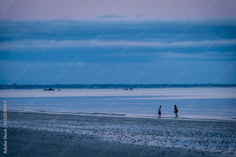 Children on holidays in France playing in the ocean in Mousterlin