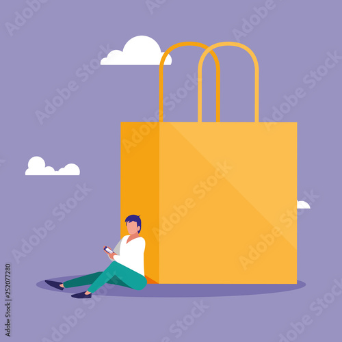 young man using smartphone with shopping bag